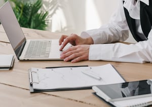 Woman sitting in a char working on her laptop on top of a coffee table.