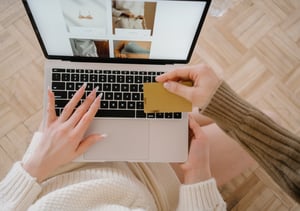 Two people shop online on a laptop computer.