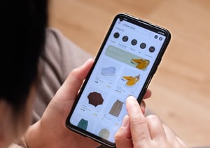 A person shopping for clothes online on their smartphone.