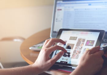 Person scrolling while online shopping on a tablet device.