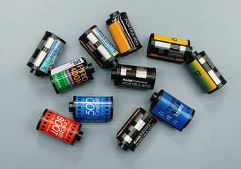 Multiple disposable camera film containers on a table.
