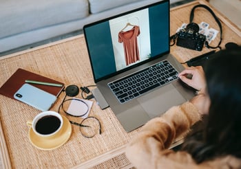 Person looking at clothing on a laptop.