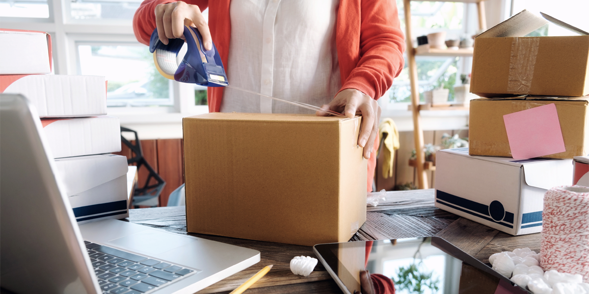 Woman packing ecommerce sales up for fulfillment with tape