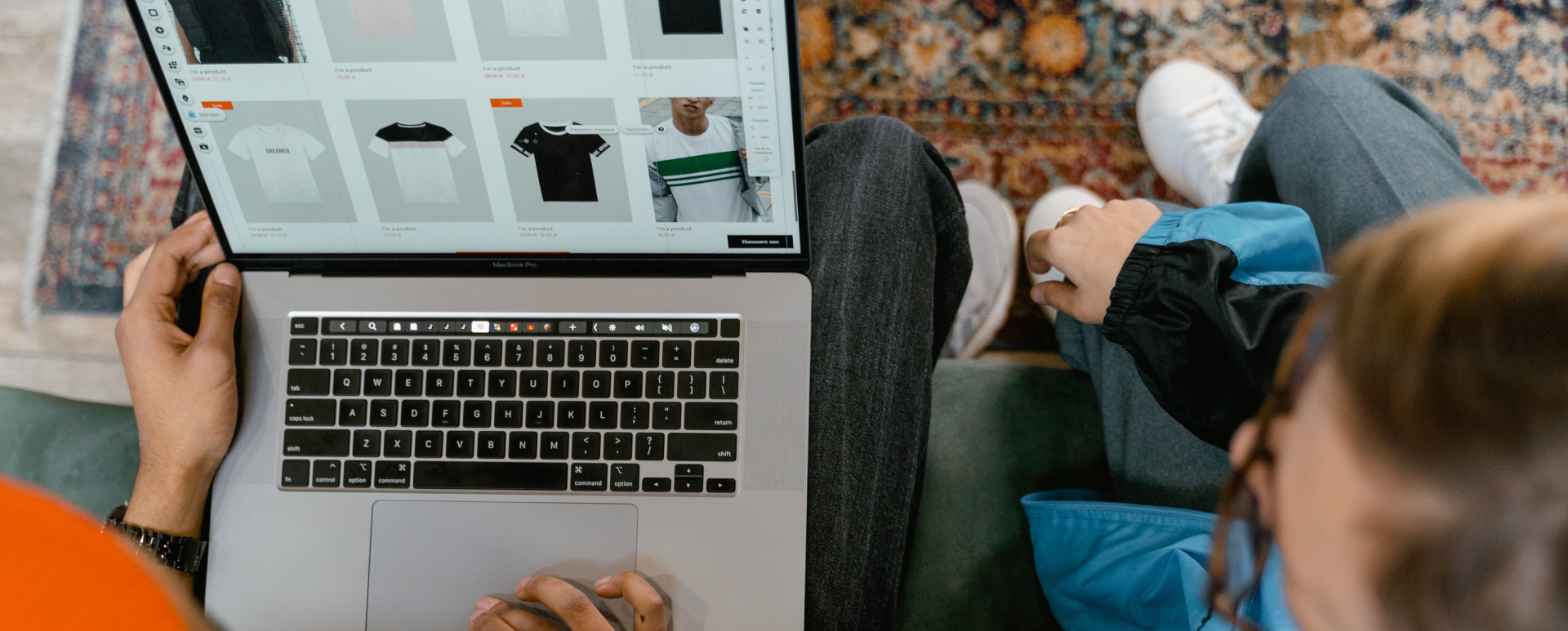 Two people sitting on a couch creating an online store for t-shirts.